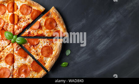 Leckere Pepperonipizza auf Schwarz konkreten Hintergrund. Blick von oben auf die Hot Pepperoni Pizza. Kopieren mit Platz für Text. Flach. Banner Stockfoto