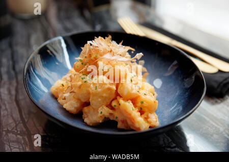 Garnelen im asiatischen Stil im Teig mit süß-saurer Sauce und Bonito Thunfisch auf Marmor tisch gekocht Stockfoto