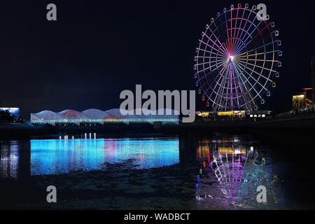 Anwohner Spaziergang auf der Regenbogenbrücke von bunten Lichtern in Qingdao Stadt beleuchtet, der ostchinesischen Provinz Shandong, 27. Juli 2019. Stockfoto