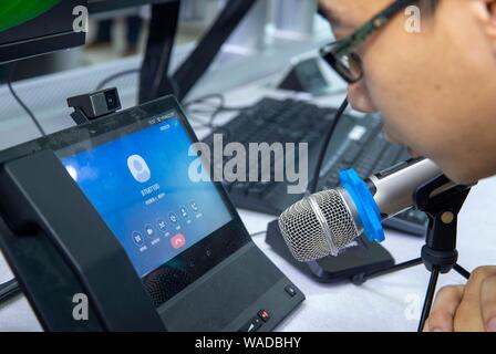 Ein Mitarbeiter interagiert mit Chinas erste künstliche Intelligenz (KI) Roboter Xiao Ai an der State Grid Yangzhou Municipal Electric Power Company in Y Stockfoto