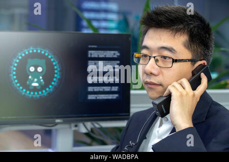 Ein Mitarbeiter interagiert mit Chinas erste künstliche Intelligenz (KI) Roboter Xiao Ai an der State Grid Yangzhou Municipal Electric Power Company in Y Stockfoto