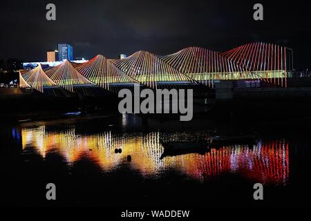 Anwohner Spaziergang auf der Regenbogenbrücke von bunten Lichtern in Qingdao Stadt beleuchtet, der ostchinesischen Provinz Shandong, 27. Juli 2019. Stockfoto