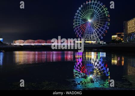 Anwohner Spaziergang auf der Regenbogenbrücke von bunten Lichtern in Qingdao Stadt beleuchtet, der ostchinesischen Provinz Shandong, 27. Juli 2019. Stockfoto