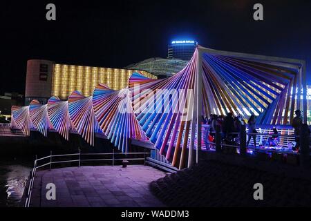 Anwohner Spaziergang auf der Regenbogenbrücke von bunten Lichtern in Qingdao Stadt beleuchtet, der ostchinesischen Provinz Shandong, 27. Juli 2019. Stockfoto