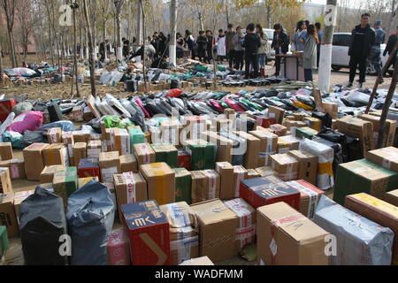 ------ Chinesische Studenten suchen in einer Masse von Parzellen, von denen die meisten von Singles online einkaufen, auf einem Pickup - Station einer Universität in Binz Stockfoto