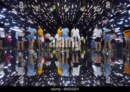 Chinesische Eltern und ihre Kinder zu Fuß durch die "Time Tunnel", die während des interaktiven Wissenschaft Ausstellung "Hawking und George's Universum' in Changsha ci Stockfoto