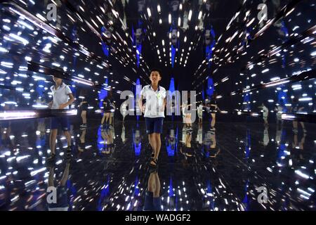 Chinesische Eltern und ihre Kinder zu Fuß durch die "Time Tunnel", die während des interaktiven Wissenschaft Ausstellung "Hawking und George's Universum' in Changsha ci Stockfoto