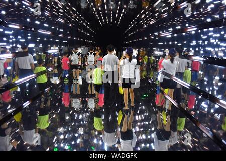 Chinesische Eltern und ihre Kinder zu Fuß durch die "Time Tunnel", die während des interaktiven Wissenschaft Ausstellung "Hawking und George's Universum' in Changsha ci Stockfoto