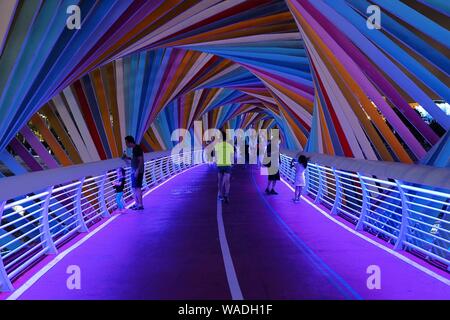 Anwohner Spaziergang auf der Regenbogenbrücke von bunten Lichtern in Qingdao Stadt beleuchtet, der ostchinesischen Provinz Shandong, 27. Juli 2019. Stockfoto