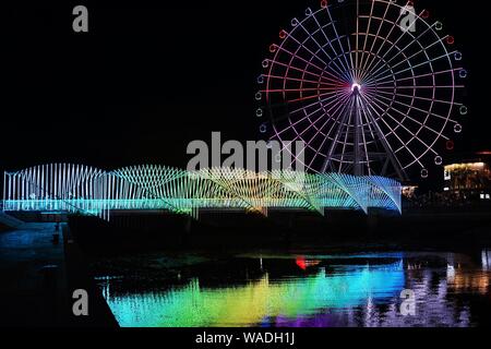 Anwohner Spaziergang auf der Regenbogenbrücke von bunten Lichtern in Qingdao Stadt beleuchtet, der ostchinesischen Provinz Shandong, 27. Juli 2019. Stockfoto