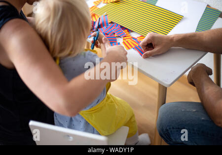 Stuttgart, Deutschland. 15 Aug, 2019. Ein paar Schnitte bunte Papier mit ihrer Tochter. Die Familie nicht einen Platz für ihre Tochter in einem öffentlichen Kindergarten in Stuttgart erhalten, obwohl die Fristen. Credit: Fabian Sommer/dpa/Alamy leben Nachrichten Stockfoto