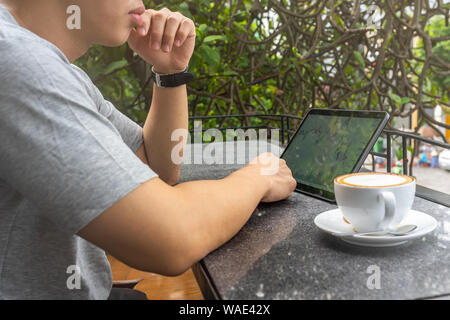 Junge asiatische Geschäftsmann ansehen Stock Trading graph auf Tablet Stockfoto