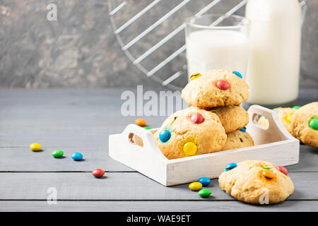 Hausgemachte Kekse mit Multi-farbigen Bonbons Dragees in einem Stapel auf einem grauen Tabelle Hintergrund. Kopieren Sie Platz. Horizontale Rahmen. Close-up Selektive f Stockfoto