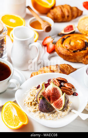 Frühstück mit Müsli, Waffeln, Croissants und Obst. Weißer Hintergrund. Stockfoto