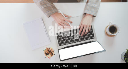 Blick von oben auf die geschäftsfrau Hand tippen auf Laptop mit Kaffeetasse Stockfoto