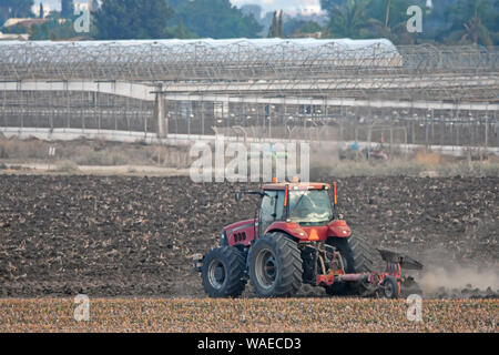 Roter Traktor Pflügen Stockfoto