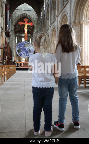 Peterborough, Großbritannien. 19 Aug, 2019. Zwei kleine stand auf der "Gaia" Erde in Peterborough Kathedrale zu suchen. Peterborough Kathedrale ist für das Hosting einer touring Kunstwerk 'Gaia', des Planeten Erde. "Gaia" der britische Künstler Luke Jerram erstellt wurde, und die Erde, mit 7 Meter Durchmesser, in Peterborough Kathedrale, im 12. Jahrhundert bis zum 15. September 2019 gebaut. Gaia, die Erde Artwork, Peterborough Kathedrale, Peterborough, Cambridgeshire, am 19. August 2019. Credit: Paul Marriott/Alamy leben Nachrichten Stockfoto
