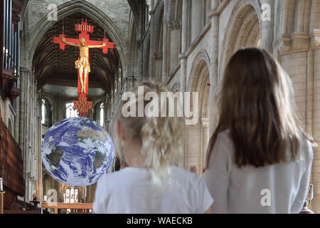 Peterborough, Großbritannien. 19 Aug, 2019. Zwei kleine stand auf der "Gaia" Erde in Peterborough Kathedrale zu suchen. Peterborough Kathedrale ist für das Hosting einer touring Kunstwerk 'Gaia', des Planeten Erde. "Gaia" der britische Künstler Luke Jerram erstellt wurde, und die Erde, mit 7 Meter Durchmesser, in Peterborough Kathedrale, im 12. Jahrhundert bis zum 15. September 2019 gebaut. Gaia, die Erde Artwork, Peterborough Kathedrale, Peterborough, Cambridgeshire, am 19. August 2019. Credit: Paul Marriott/Alamy leben Nachrichten Stockfoto