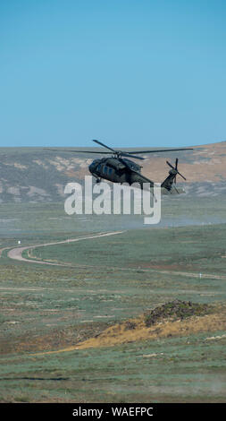 Ein UH-60 Blackhawk, aus der die Idaho Army National Guard 1-183 rd Aviation Battalion, bereitet im Orchard Combat Training Center, Boise, Idaho, Jan. 19, 2019 zu landen. Der Hubschrauber war der Transport von Idaho reg. Brad Little und anderen illustren Besucher der Training Center A-10 Thunderbolt IIs vom 190 Fighter Squadron beobachten. (U.S. Air National Guard Foto von Ryan Weiß) Stockfoto