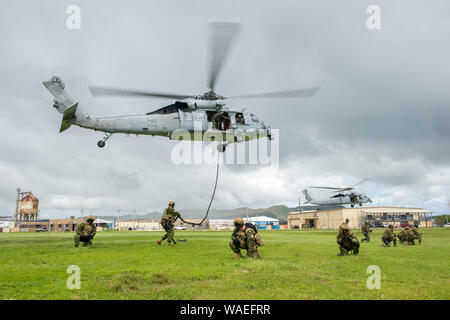 SANTA Rita, Guam (Aug. 19, 2019) Abstand Taucher der Royal Canadian Navy Fleet tauchen Einheit Atlantic defensiven Positionen Nehmen Sie nach dem schnellen Abseilen von einem MH-60S Seahawk Hubschrauber, der "Insel der Ritter" Hubschrauber Meer Combat Squadron (HSC) 25, während der Übung HYDRACRAB. HYDRACRAB ist viereck Übung durch Kräfte aus Australien, Kanada, Neuseeland, und U.S. Naval Forces. Der Zweck dieser Übung ist es, den Teilnehmenden die Beseitigung von Explosivstoffen (EOD) Kräfte zu bedienen als integrierte, leistungsfähige und starke Allied Force bereit zu reagieren. Stockfoto