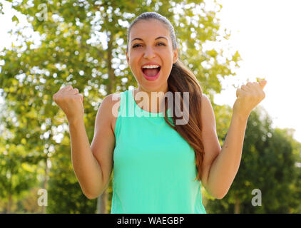 Gewinnen, erfolg konzept. Schöne, Fitness Sportliche Mädchen freut sich über den Sieg, erhebt ihre Fäuste in ein Zeichen des Sieges. Positive Emotionen und Gefühle. Stockfoto