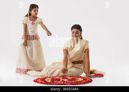 South Indian Frau, die RANGOLI mit Ihrer Tochter Stockfoto