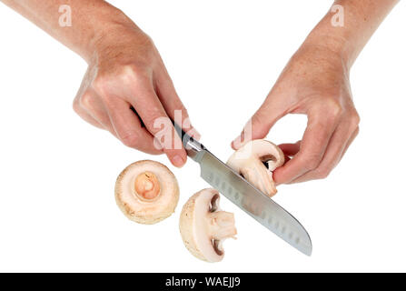 Eine alte ältere Frau hält ein Pilz in der Hand und schneidet ihn mit einem Messer. Auf weissem studio Konzept isoliert Stockfoto