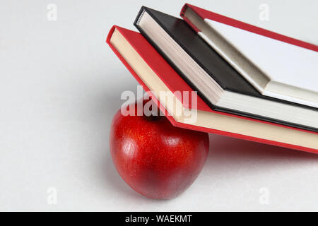 Nahaufnahme von Büchern, die einen Apfel lehnen Stockfoto