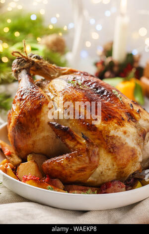 Hausgemachte geröstete Weihnachten Truthahn oder Hähnchen mit allen Seiten. Abendessen mit Festliche Lichter und Kerzen. Weihnachten Urlaub Tabelle einstellen. Stockfoto