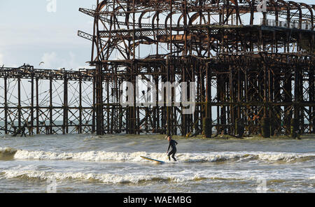 Brighton UK 20. August 2019 - ein Surfer genießt das Schöne am frühen Morgen Sonnenschein von Brighton West Pier als die Wettervorhersage in den nächsten Tagen insbesondere gegenüber der Bank Holiday Wochenende in Großbritannien Kredit zu verbessern: Simon Dack/Alamy leben Nachrichten Stockfoto