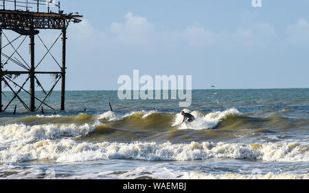 Brighton UK 20. August 2019 - ein Surfer genießt das Schöne am frühen Morgen Sonnenschein von Brighton West Pier als die Wettervorhersage in den nächsten Tagen insbesondere gegenüber der Bank Holiday Wochenende in Großbritannien Kredit zu verbessern: Simon Dack/Alamy leben Nachrichten Stockfoto