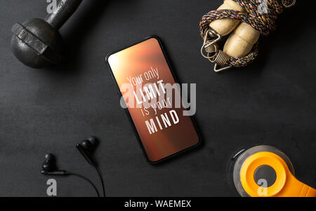 Ihre einzige Grenze ist Ihr Verstand. Inspirational motivational quotes Fitness gesund Ziele mit mockup Mobiltelefon auf grunge schwarz Tisch mit Kurzhanteln, J Stockfoto