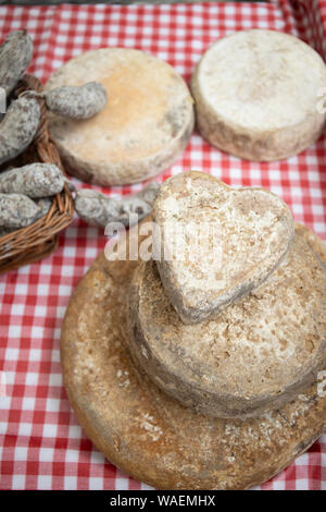 Artisan Herz Käse und Wurst, typische italienische Produkte, auf einen Tisch und halten Sie einen Bauernmarkt ausgesetzt. Vertikale erschossen. Stockfoto