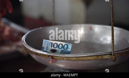 Geld auf der Waage in der Straße Markt. 1000 Philippinischen Pesos auf einer alten Waage. Shopping Konzept. Stockfoto