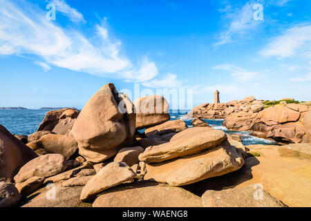 Die Ploumanac'h Leuchtturm, genannt, Ruz, an der Küste des Rosa Granits in Perros-Guirec, Bretagne, mit großen Granitfelsen im Vordergrund. Stockfoto