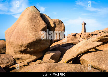 Die Ploumanac'h Leuchtturm, genannt, Ruz, an der Küste des Rosa Granits in Perros-Guirec, Bretagne, mit großen Granitfelsen im Vordergrund. Stockfoto