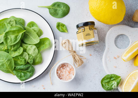 Zutaten für Fleisch oder Geflügel Kochen - Zitrone, Spinat, Honig, Senf und Salz. Ansicht von oben. Stockfoto