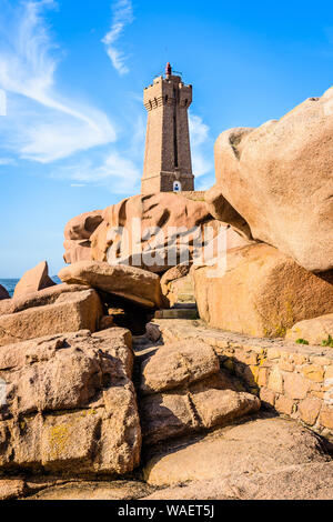 Die Ploumanac'h Leuchtturm, genannt, Ruz, an der Küste des Rosa Granits in Perros-Guirec, Bretagne, mit großen Granitfelsen im Vordergrund. Stockfoto