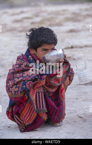 Fakirani junge Trinken eine Schüssel mit Milch, große Rann von Kutch Wüste, Gujarat, Indien. Stockfoto