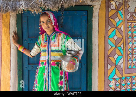 Mädchen in traditionellen Tuch vor einem Haus, Khavda Tourist Village, tolle Rann von Kutch Wüste, Gujarat, Indien. Stockfoto