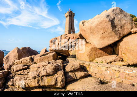 Die Ploumanac'h Leuchtturm, genannt, Ruz, an der Küste des Rosa Granits in Perros-Guirec, Bretagne, mit großen Granitfelsen im Vordergrund. Stockfoto