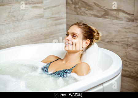 Schöne Frau entspannen in der Badewanne mit Hydromassage Therapie in der SPA Stockfoto