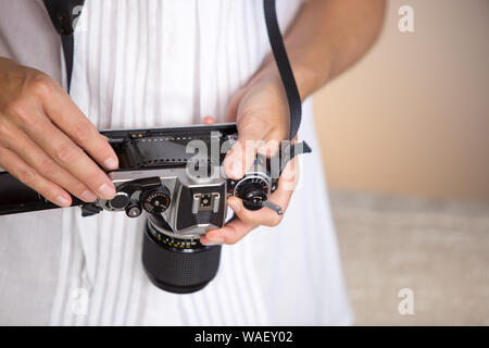 Kontrast zwischen Alt und Modern Times: Eine junge Frau Geigen mit Ihrer vintage Kamera hängen von ihrem Ansatz Stockfoto