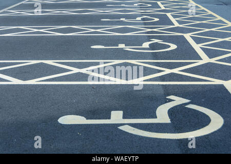 Nahaufnahme von Blue Badge Rollstuhl Symbol und behinderten Parkplatz Schilder in einem Parkplatz Stockfoto
