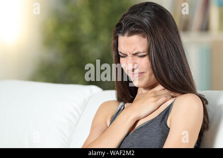 Frau leiden Kehle ache Sitzen sitzen auf einer Couch im Wohnzimmer zu Hause Stockfoto