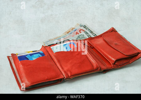 Rot Leder Geldbörse mit Euro Banknoten und Kreditkarten gefüllt Stockfoto