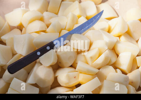 Frisch geschälten Kartoffeln und Küchenmesser lag auf einem Tisch, Ansicht von oben Stockfoto