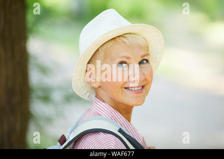 Close-up Happy reife Frau in hat stand draußen und sieht zurück Stockfoto