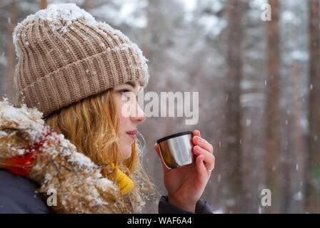 Mädchen hält in ihrer Hand eine Tasse Tee (Thermos gap) im Freien an einem frostigen Tag Stockfoto