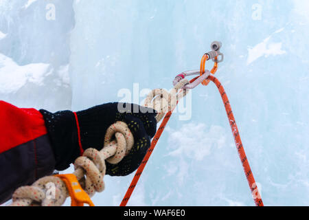 Eisklettern mit Eis Schraube, Seil, Karabiner und Kletterer arm Anker, Nahaufnahme Stockfoto